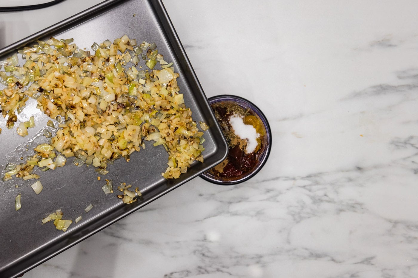 adding onion and garlic to food processor with chicken tinga ingredients