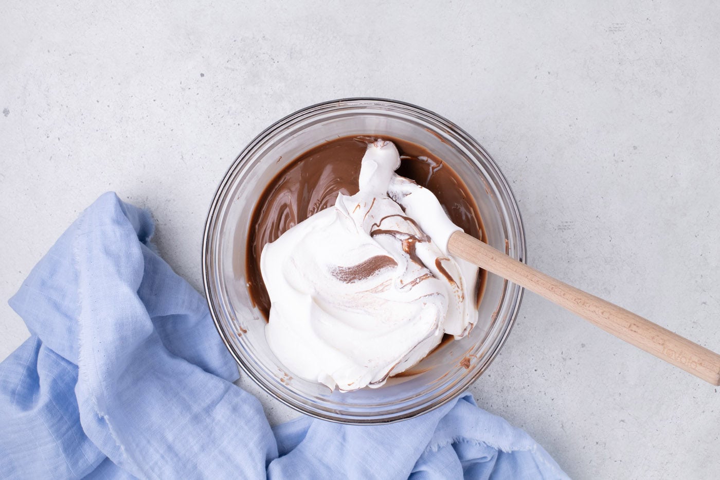 folding cool whip into melted chocolate in a bowl