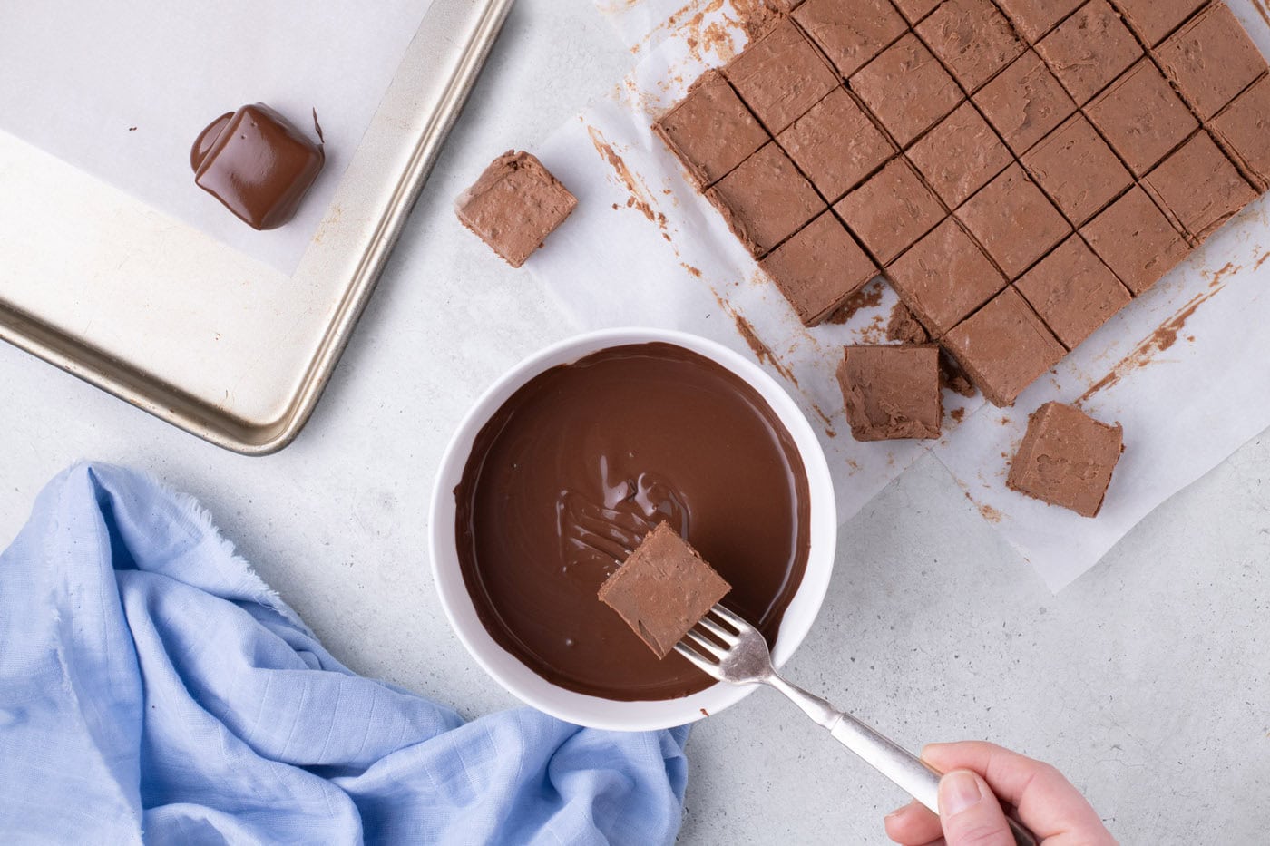 dipping cool whip candy into melted chocolate with a fork