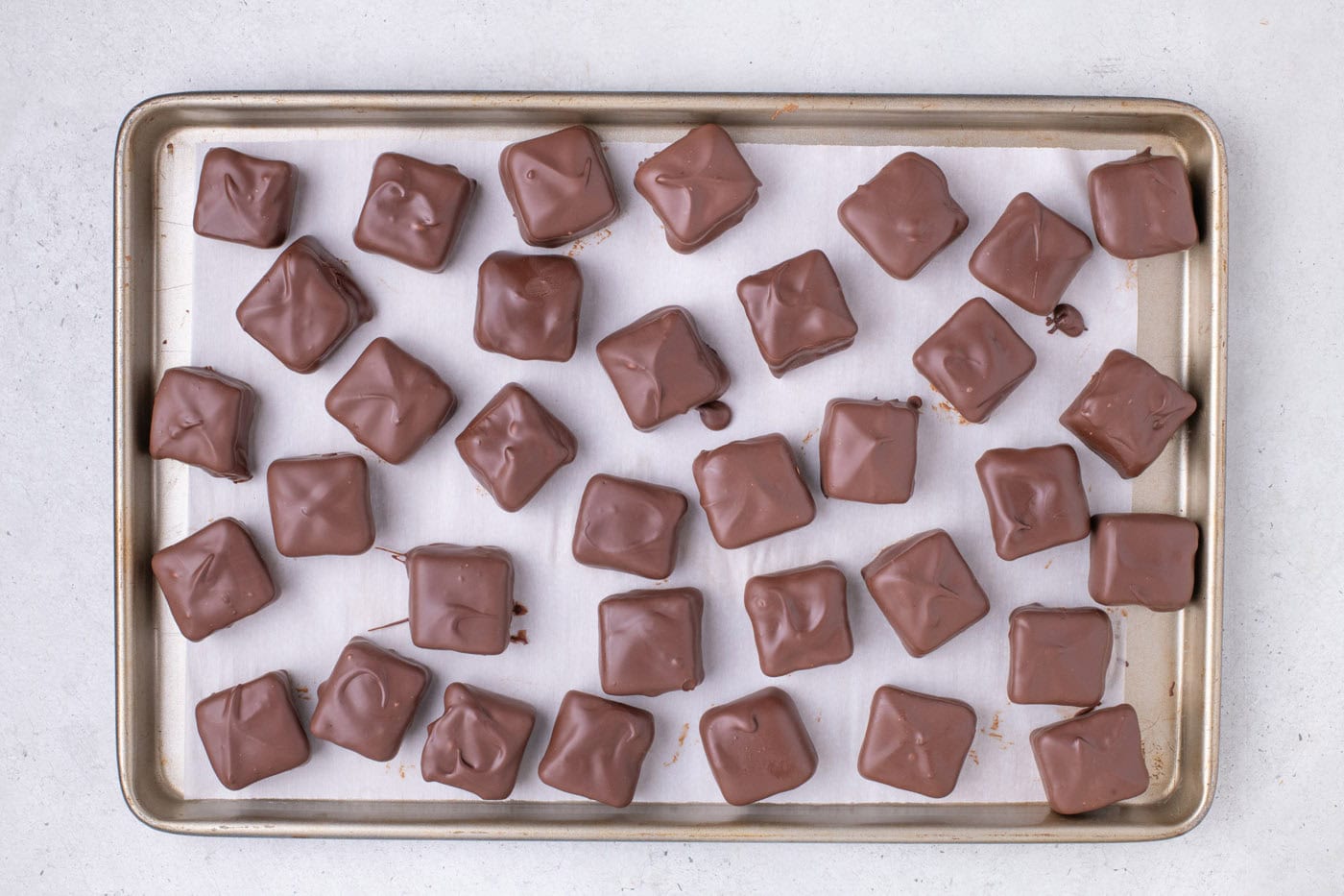 chocolate dipped cool whip candy on a baking sheet