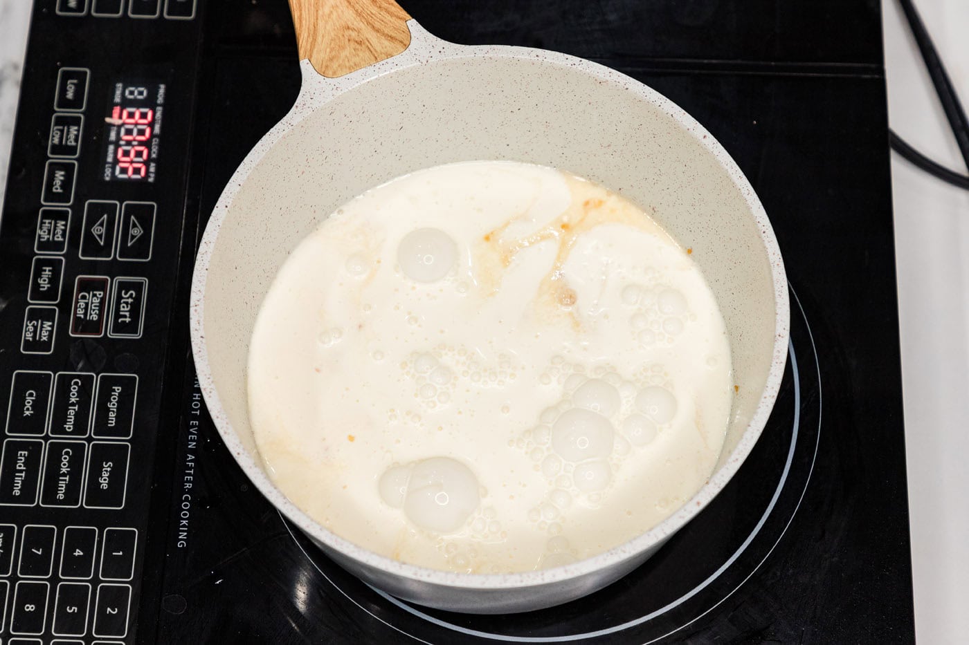 heavy cream adding to skillet with wine and garlic