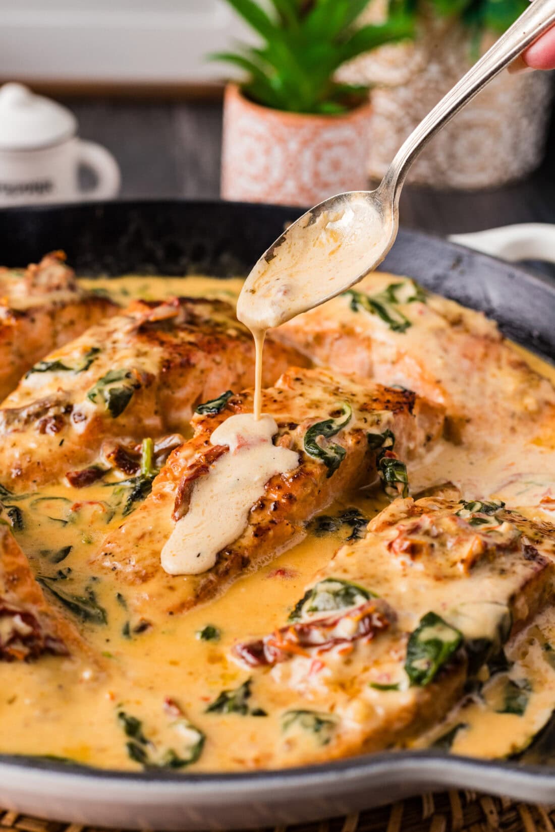 Sauce being drizzled on top of Creamy Salmon in a skillet