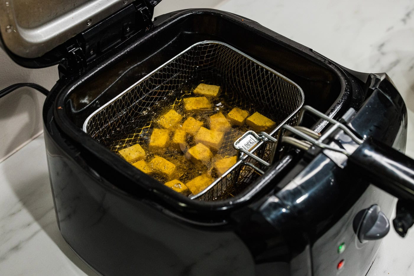 frying tofu in a deep fryer