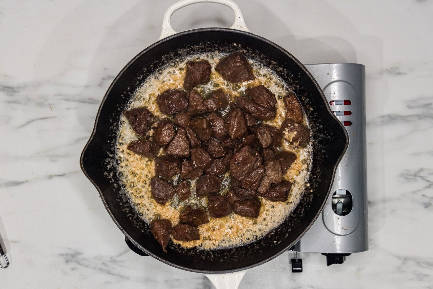 steak bites in a skillet with garlic utter