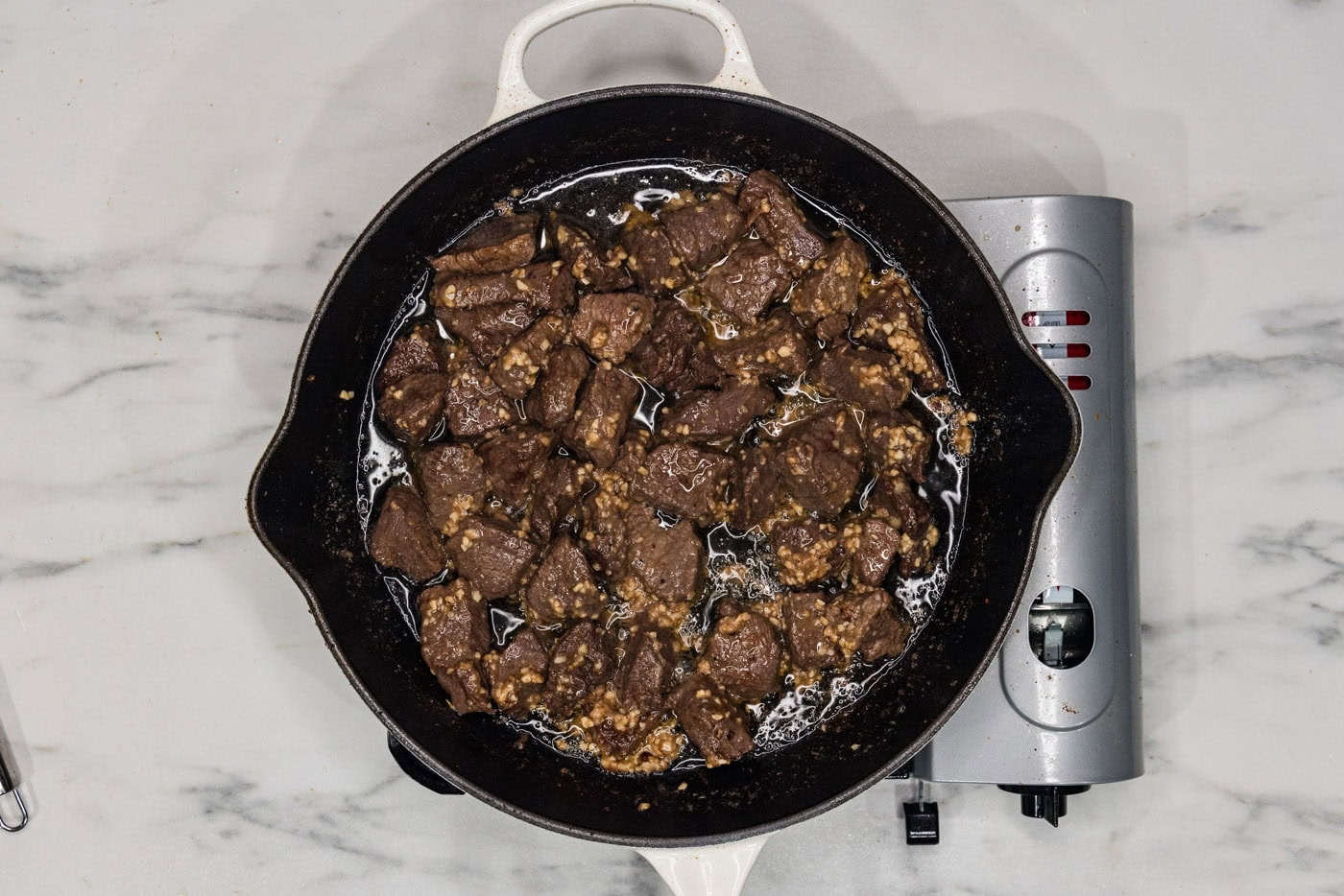 overhead of garlic butter steak bites in a skillet