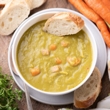 Bowl of Instant Pot Split Pea Soup with a slice on bread on it