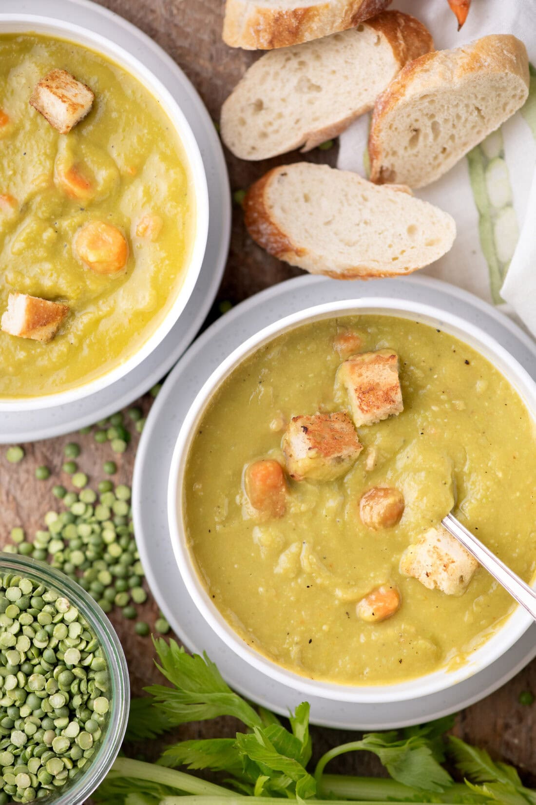 Two bowls of Instant Pot Split Pea Soup with bread on the side