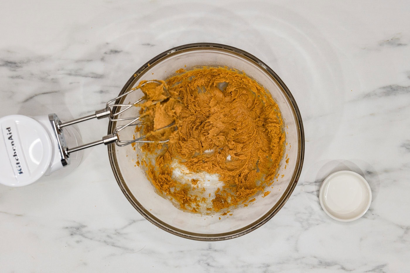 keto peanut butter cookie dough in a bowl with hand mixer whisk