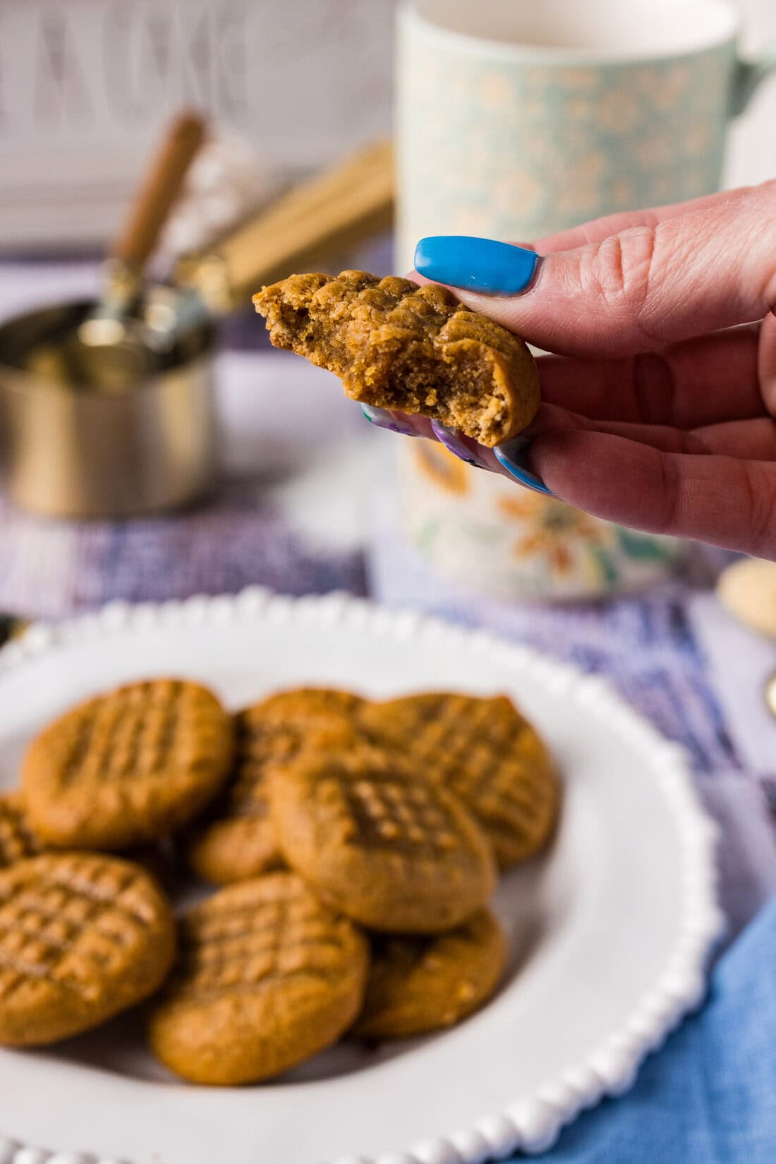 Hand holding up a Keto Peanut Butter Cookie with a bite removed