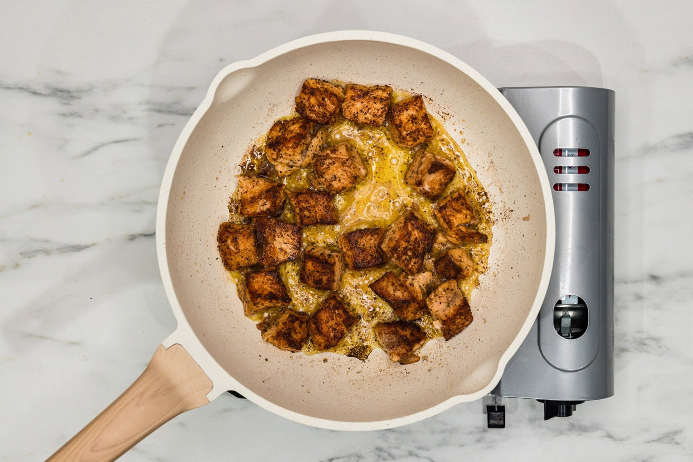 cooked salmon cubes in a skillet