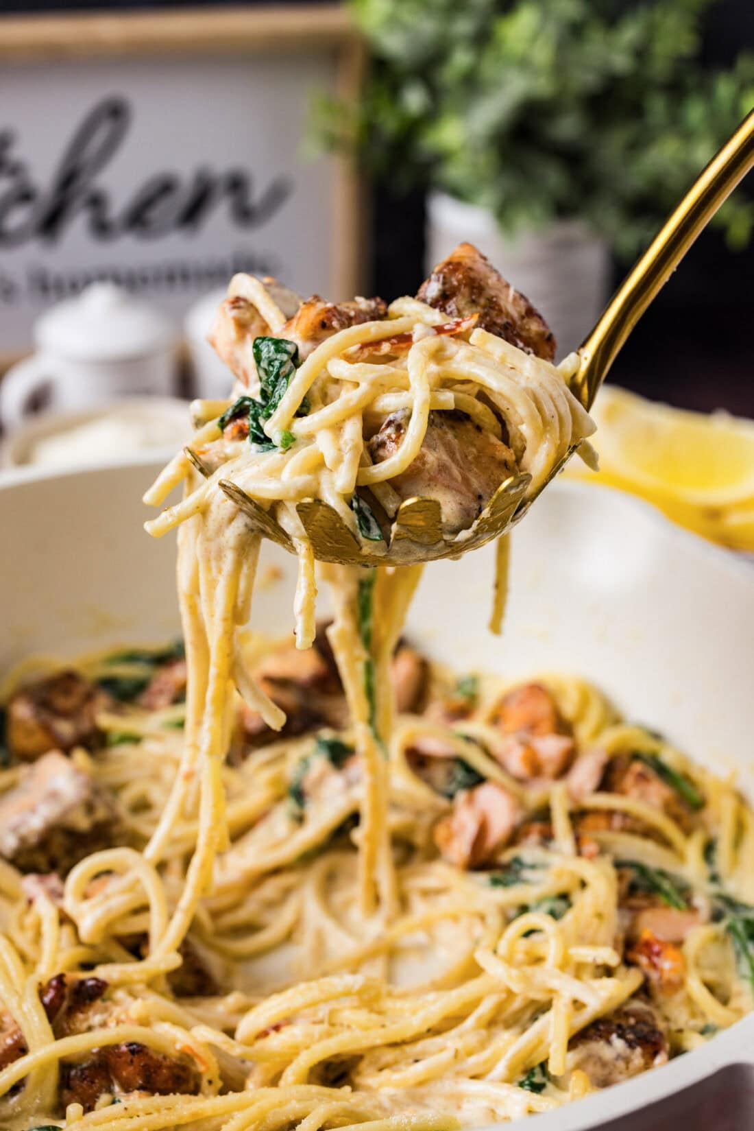 Spoonful of Salmon Pasta held above a skillet of Salmon Pasta