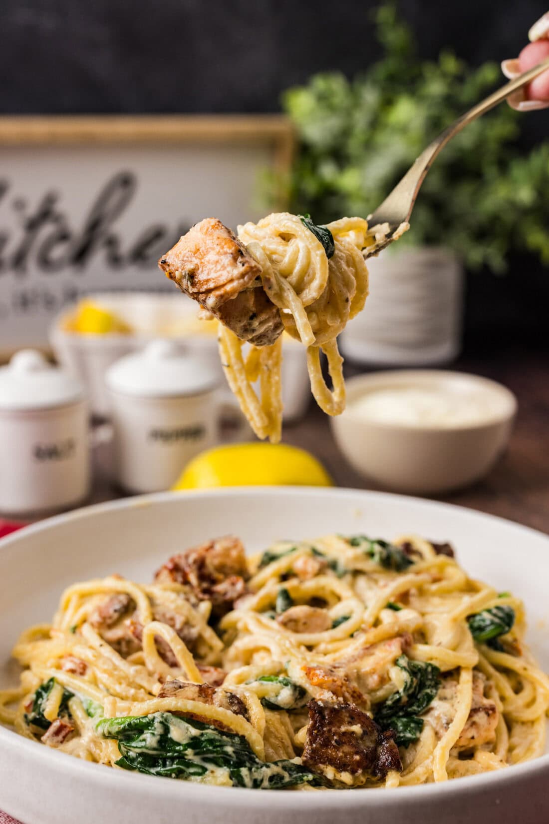 Forkful of Salmon Pasta held above a plate of Salmon Pasta