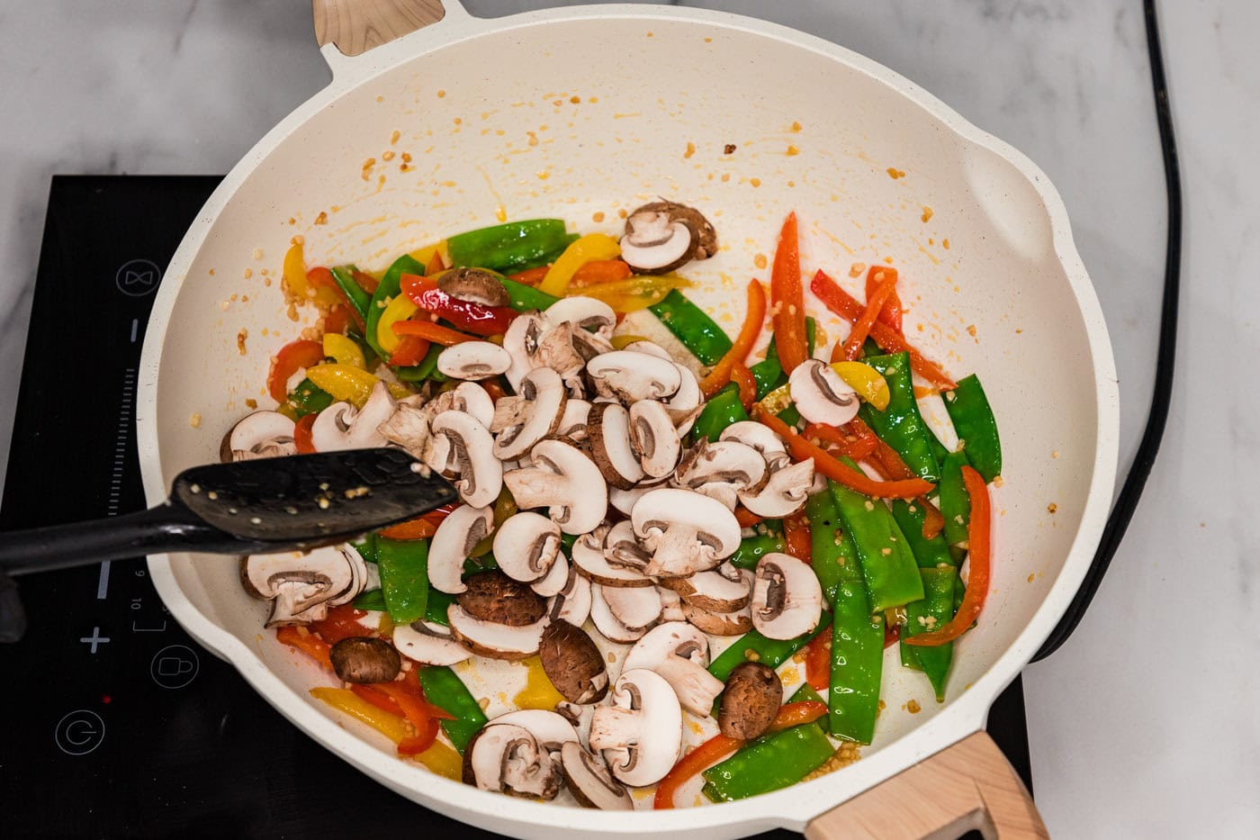 mushrooms, snow peas, and bell peppers in a skillet