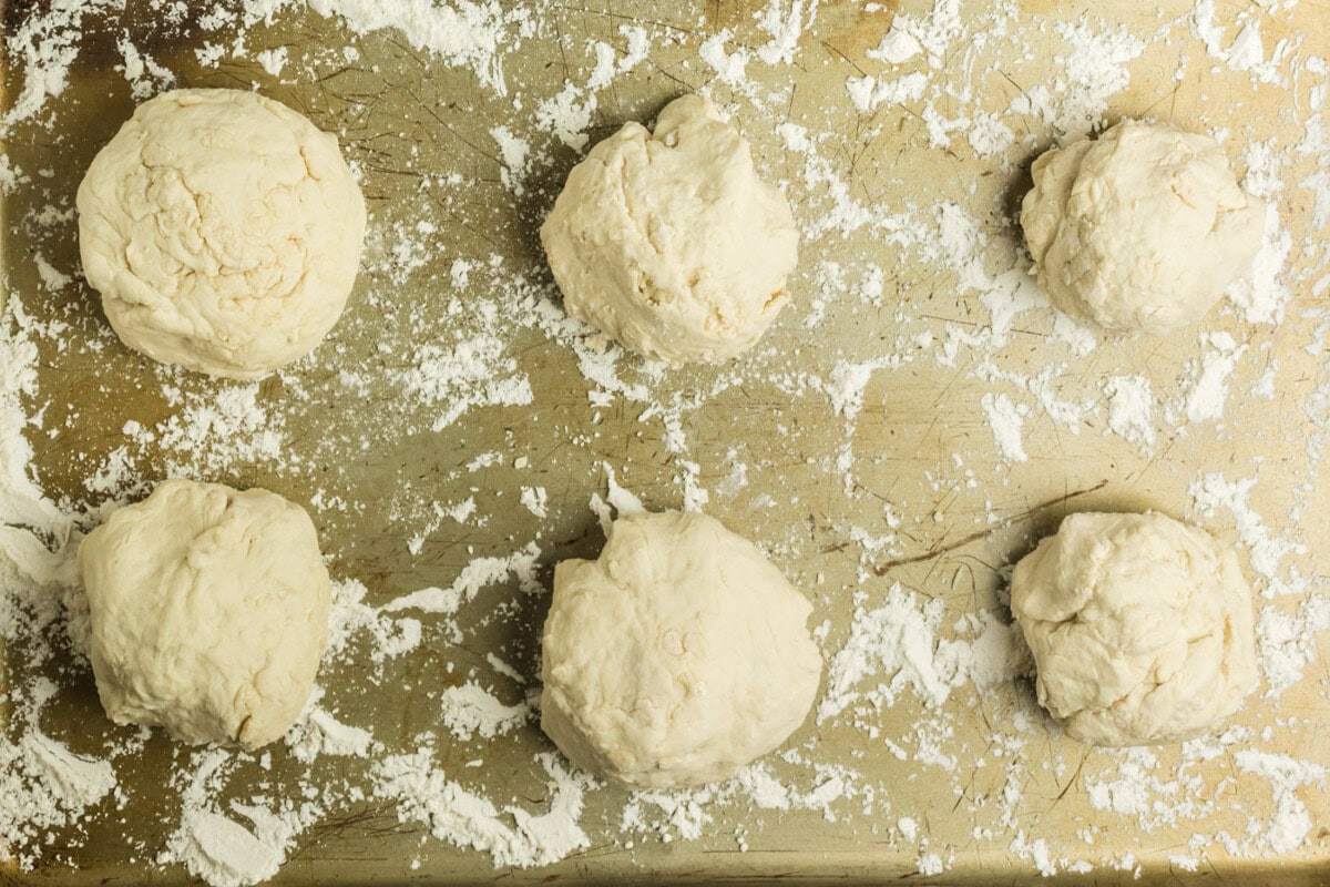 Floured cookie sheet with 6 dough pieces on it