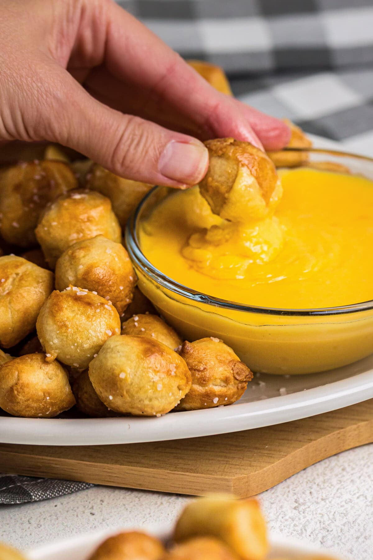 Air Fryer Pretzel Bite being dipping into cheese sauce