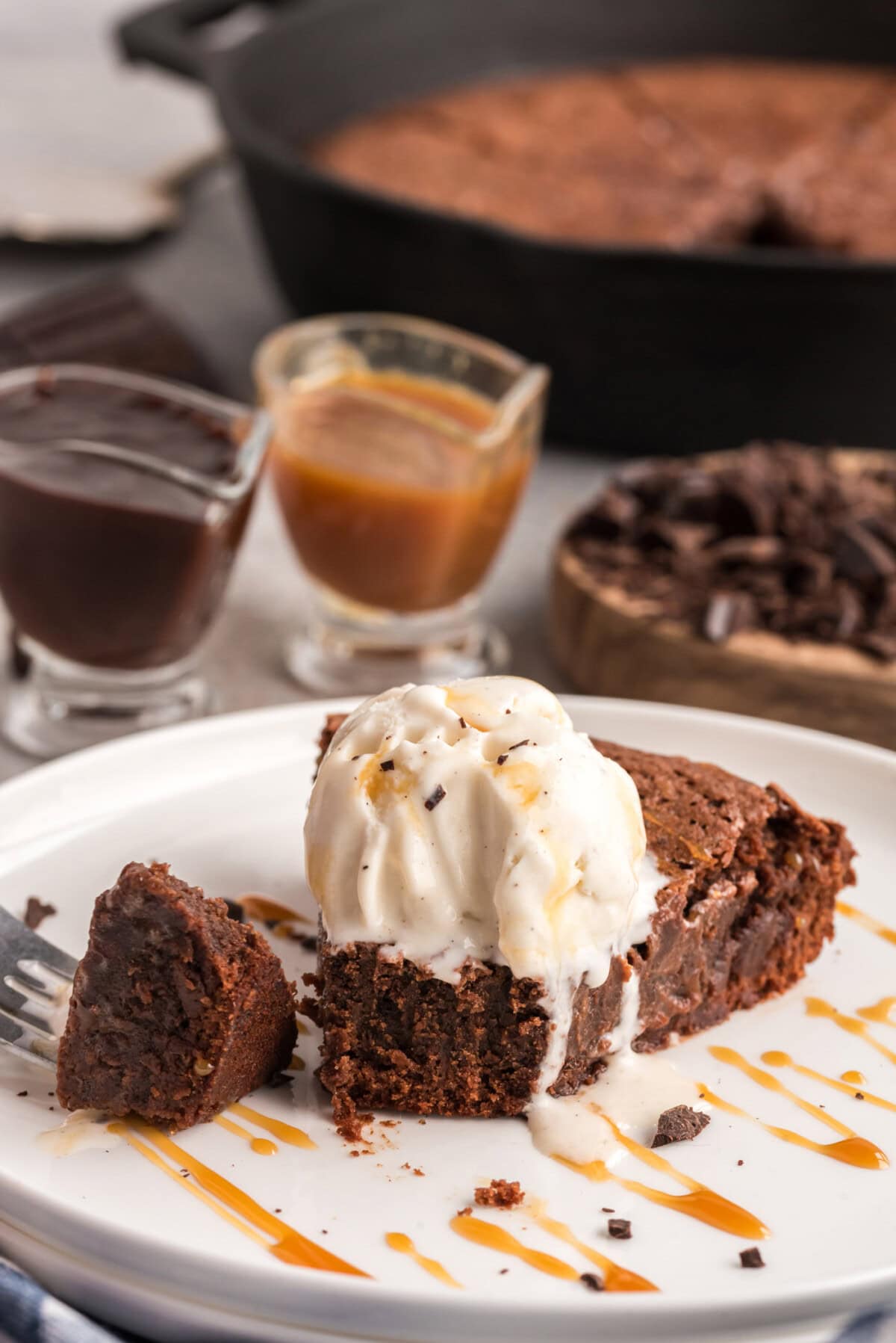 Slice of Cast Iron Skillet brownies on a plate with ice cream on top