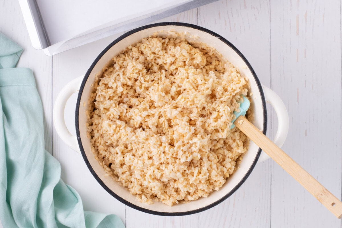 mixing melted marshmallows with rice krispie cereal