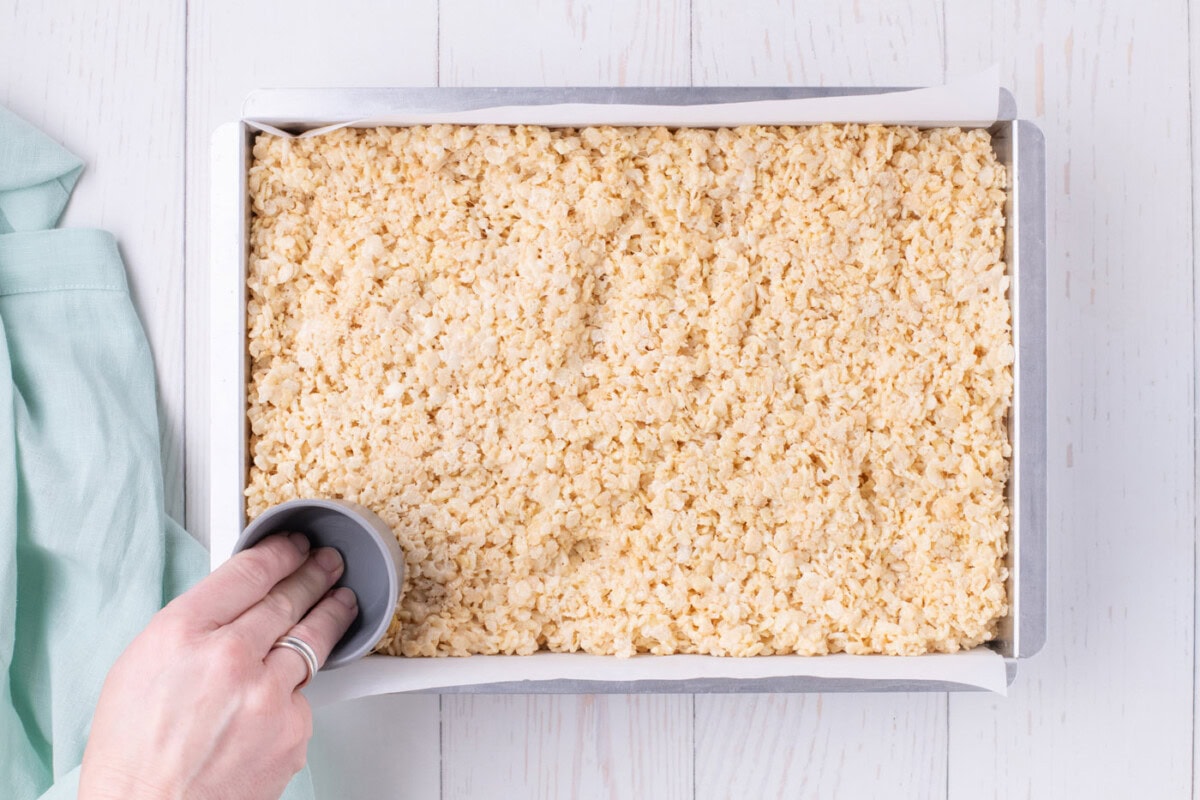 pressing rice krispie treats into baking dish