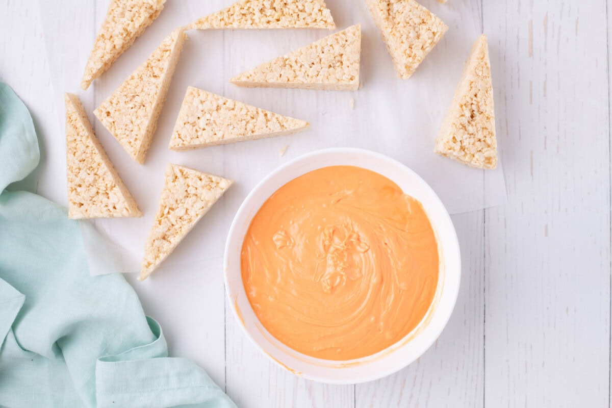 melted orange chocolate next to rice krispie triangles