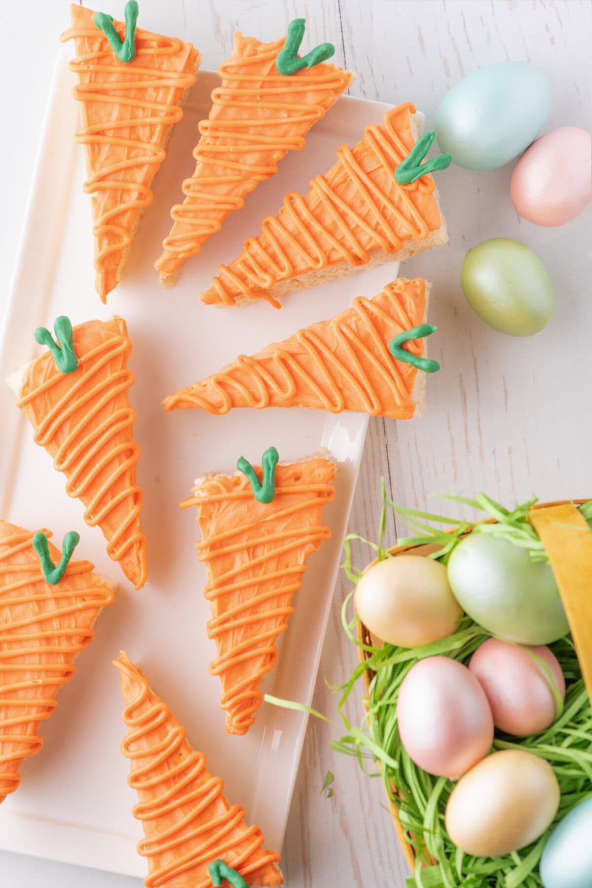 Carrot Rice Krispy Treats on a white platter with Easter eggs to the side