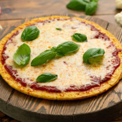 Pizza made with a Cauliflower Pizza Crust on a wooden board