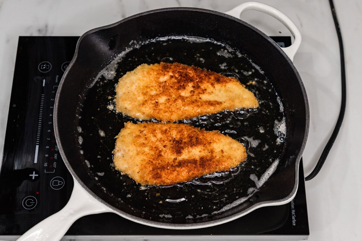 frying panko chicken in a skillet of oil