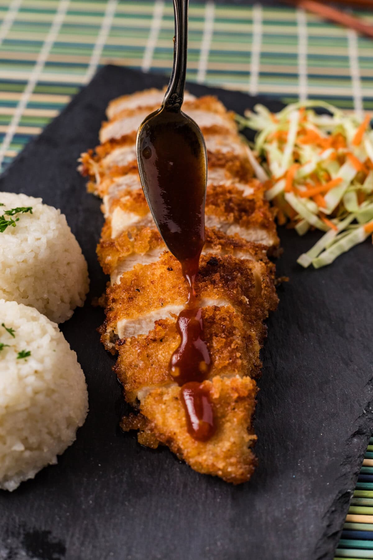 Glaze being drizzled over Chicken Katsu