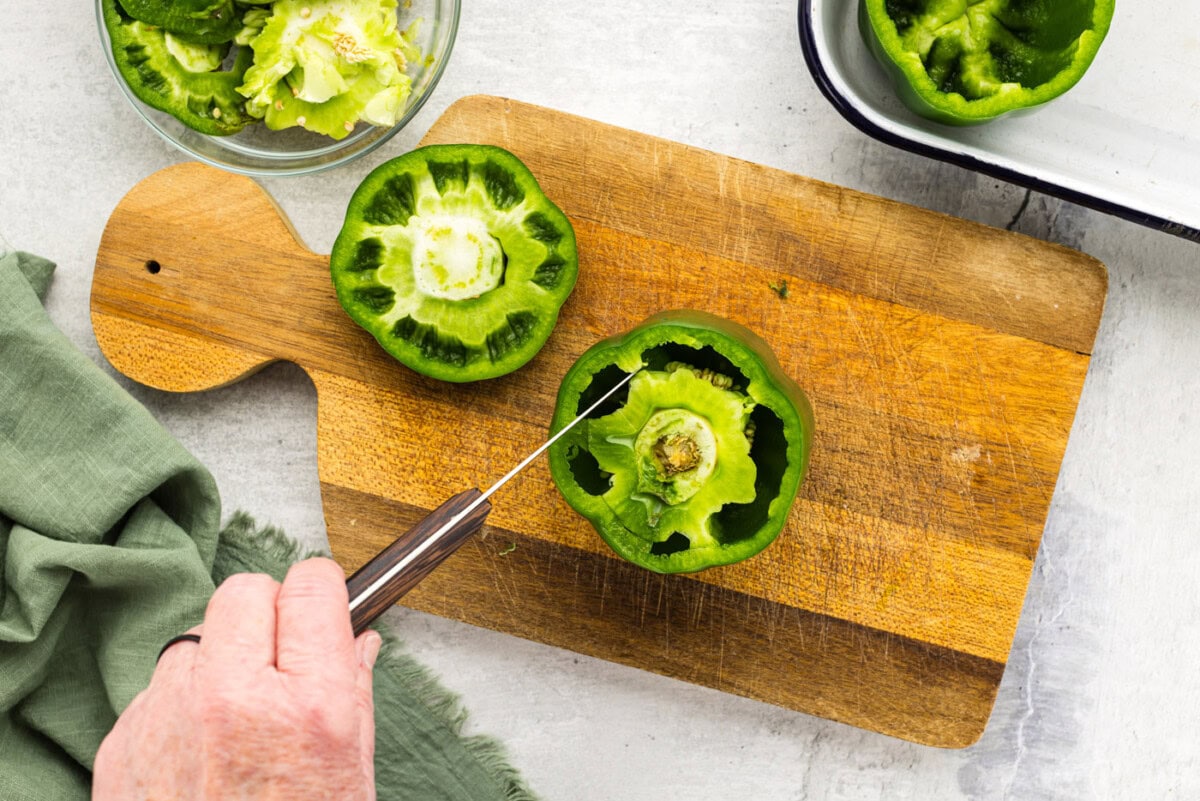 knife cutting membrane out of green bell pepper