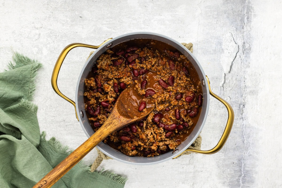 chili in a pot on a wooden spoon