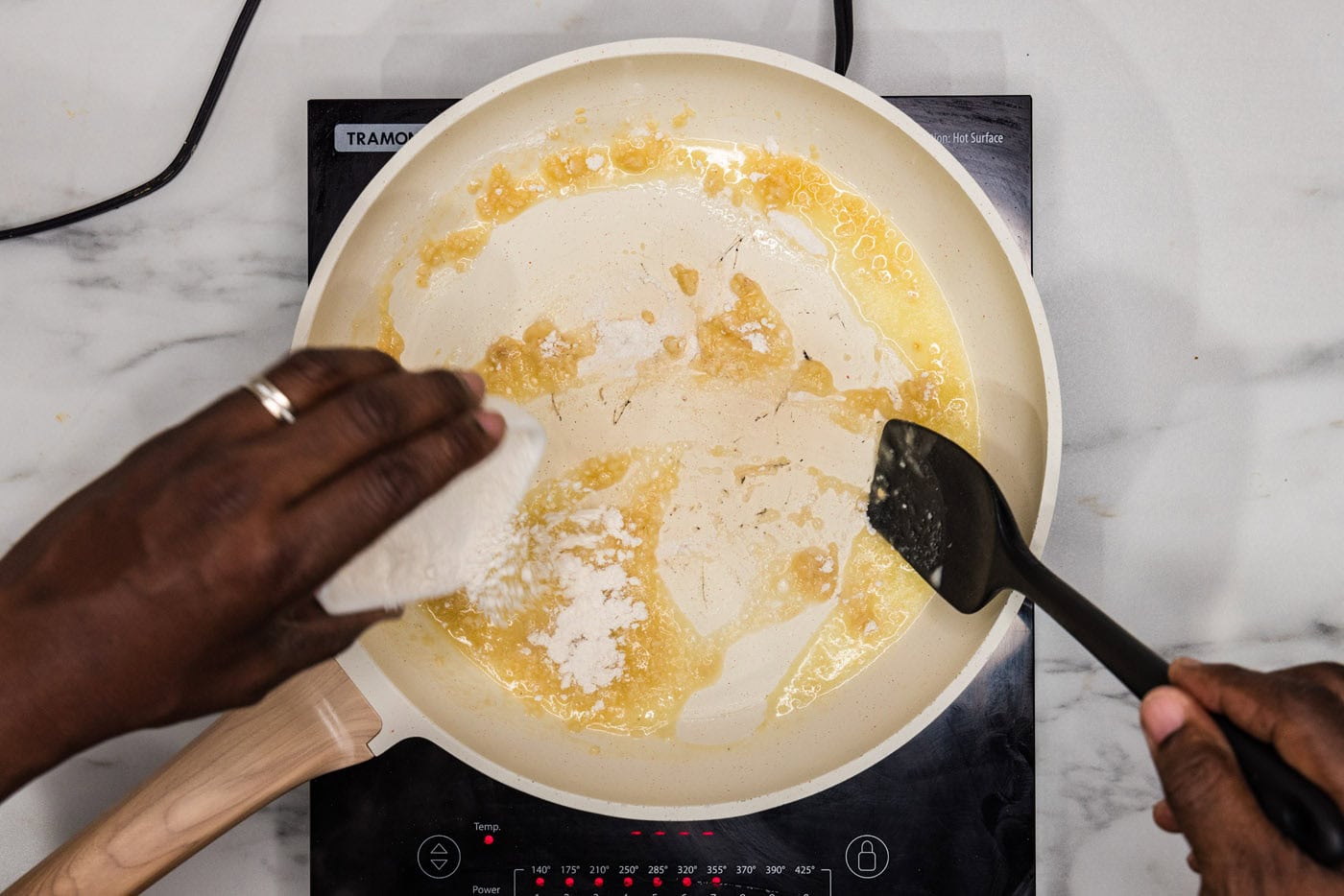 sprinkling flour into skillet with butter and garlic