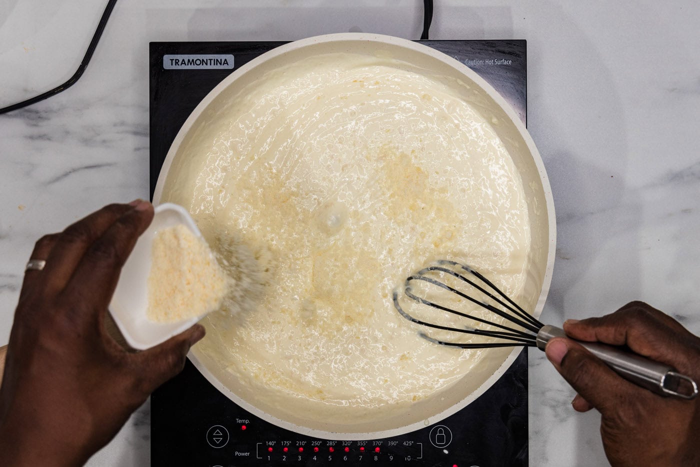 whisking parmesan cheese into lemon cream sauce