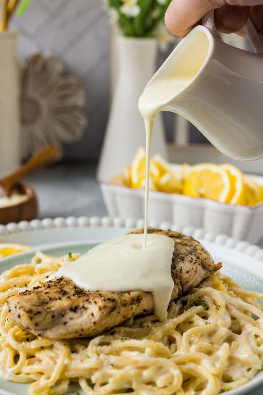 Lemon Cream Sauce being poured over a chicken breast