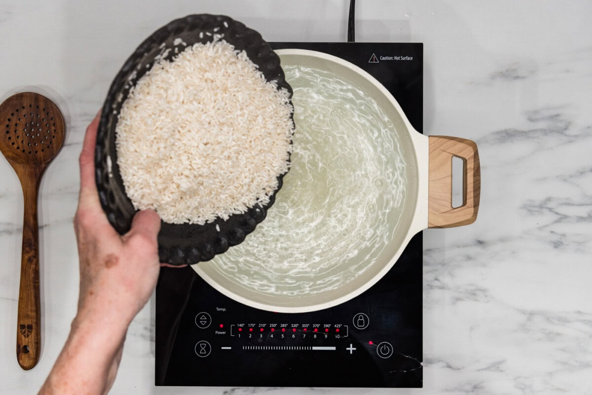 pouring rice into boiling water