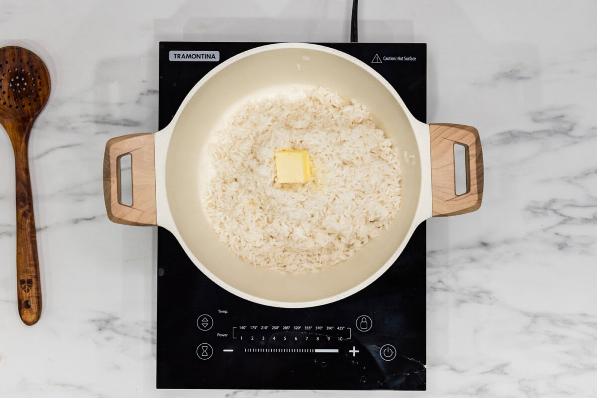 butter pat on top of rice in a pot