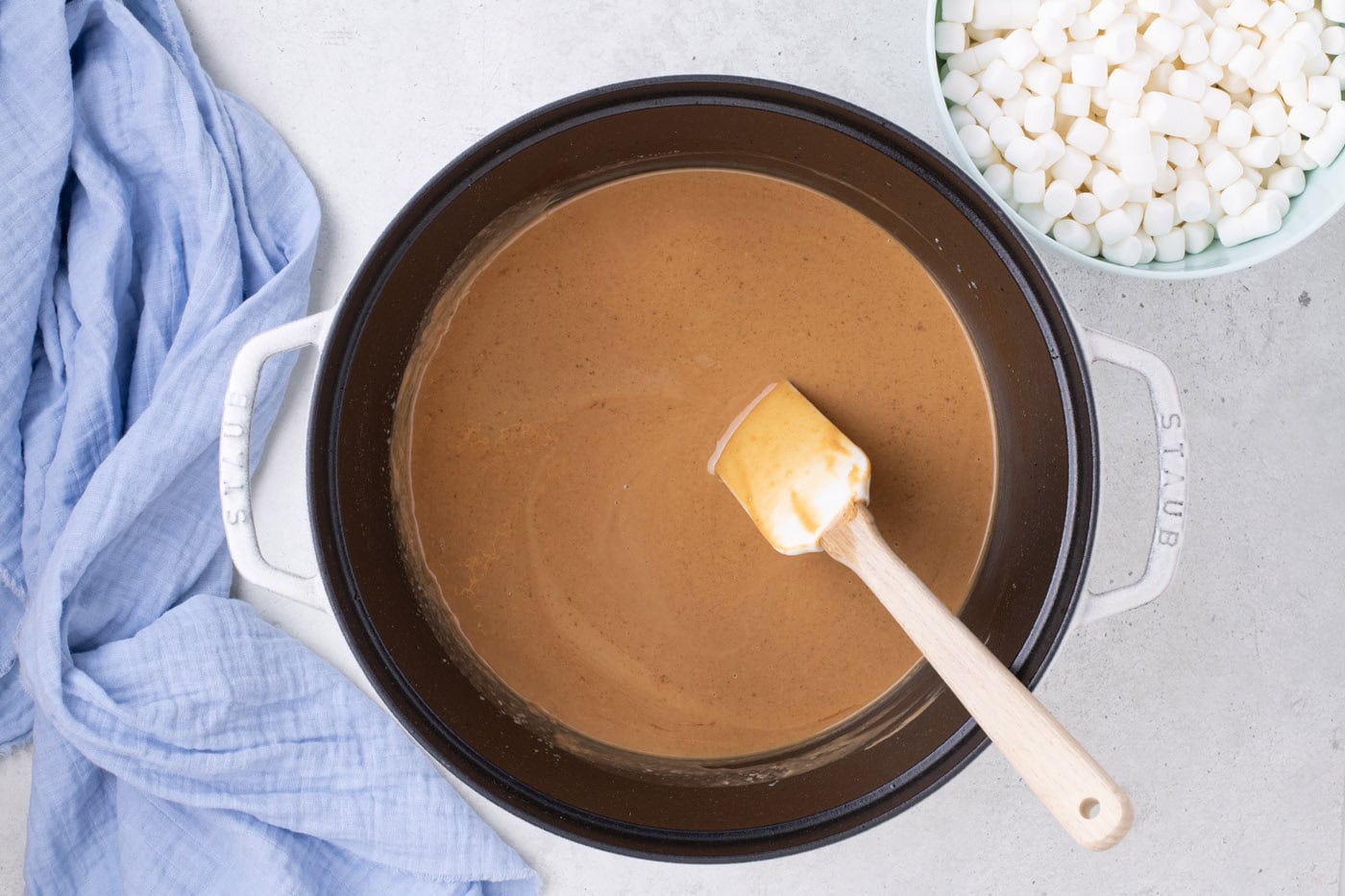 melted peanut butter in a pot with a rubber spatula