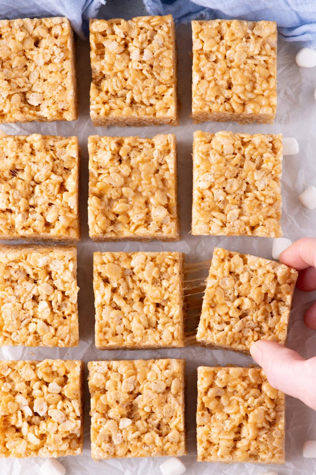 Peanut Butter Rice Krispie Treats cut into squares resting on parchment paper