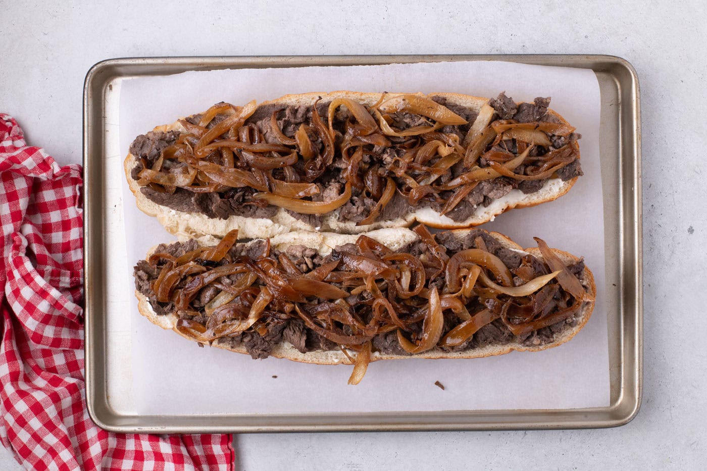 caramelized onions on top of cooked steak and loaf of bread