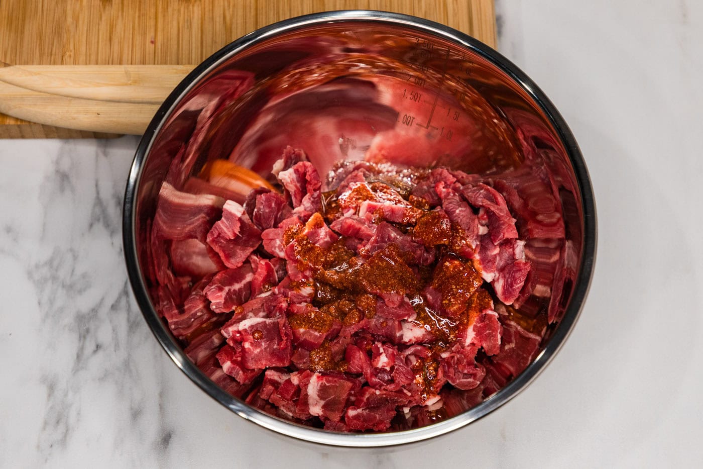 sliced steak in a bowl with olive oil and seasonings