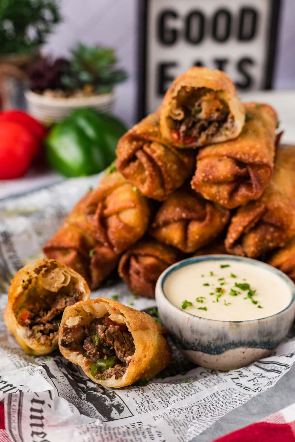 Stack of Philly Cheesesteak Egg Rolls with one cut in half