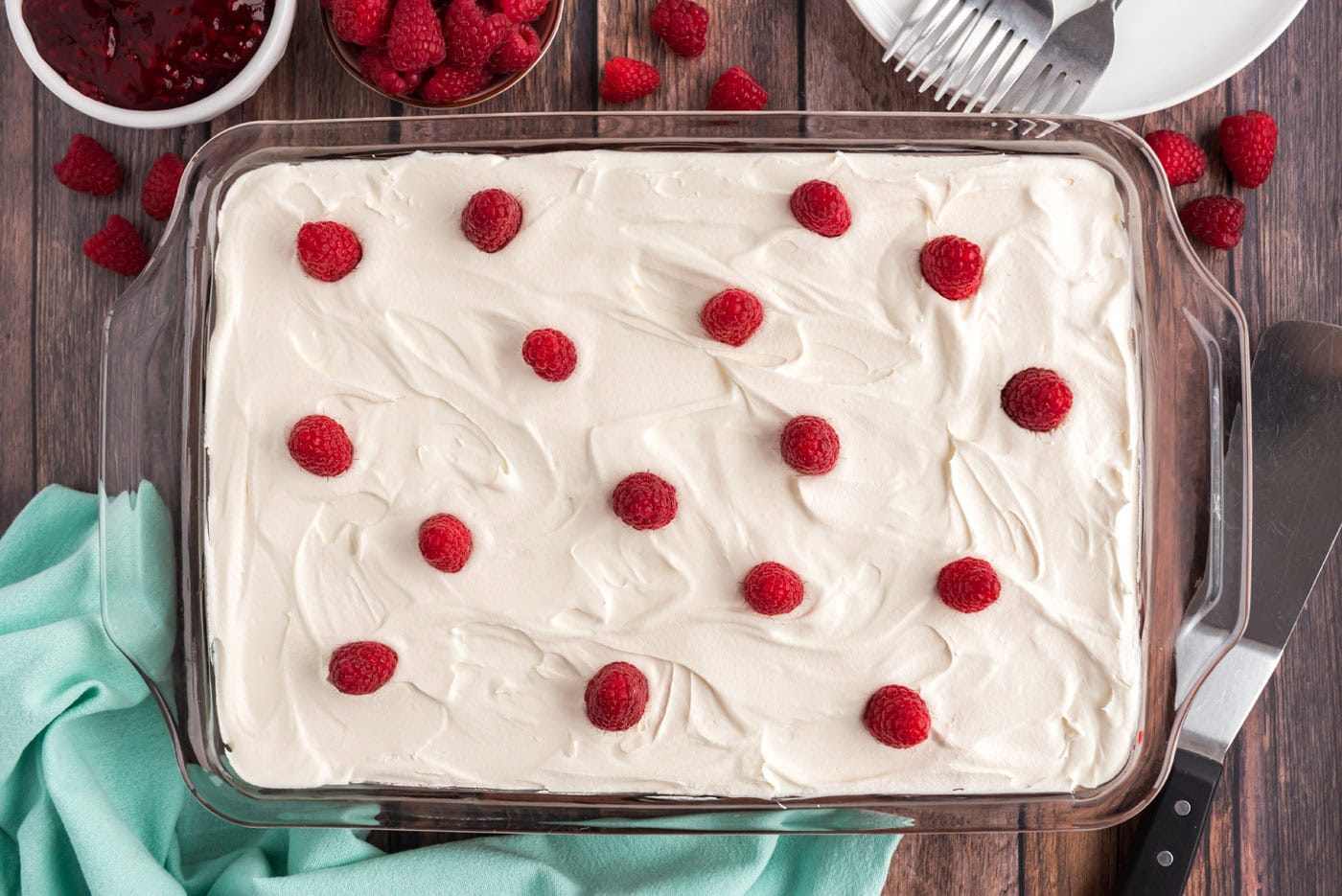 fresh raspberries on top of raspberry cake with cool whip