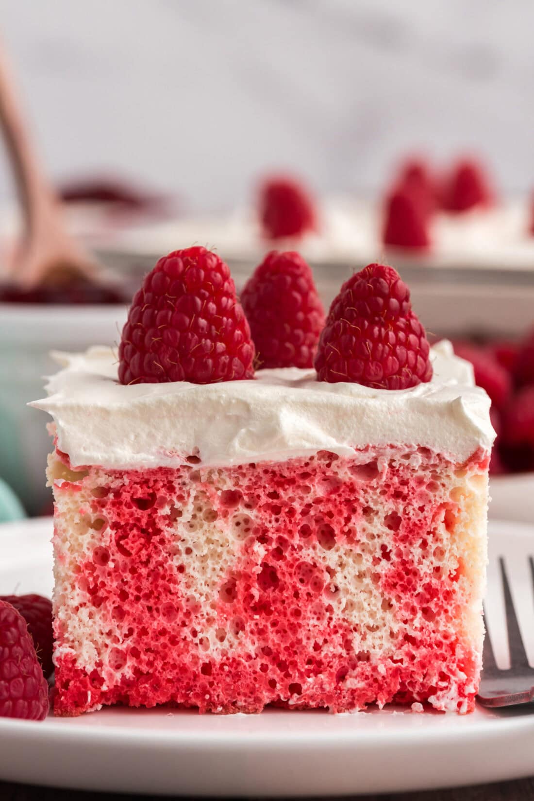 Slice of Raspberry Poke Cake on a plate