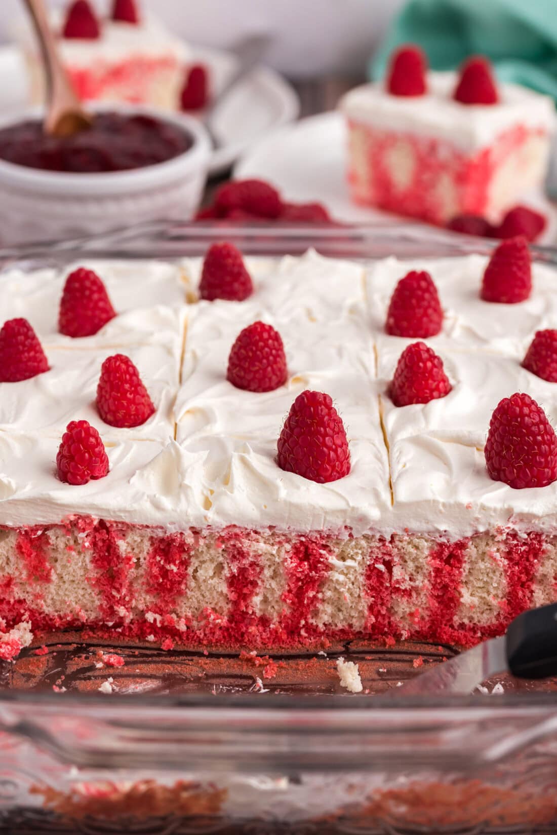 Pan of Raspberry Poke Cake with slices removed