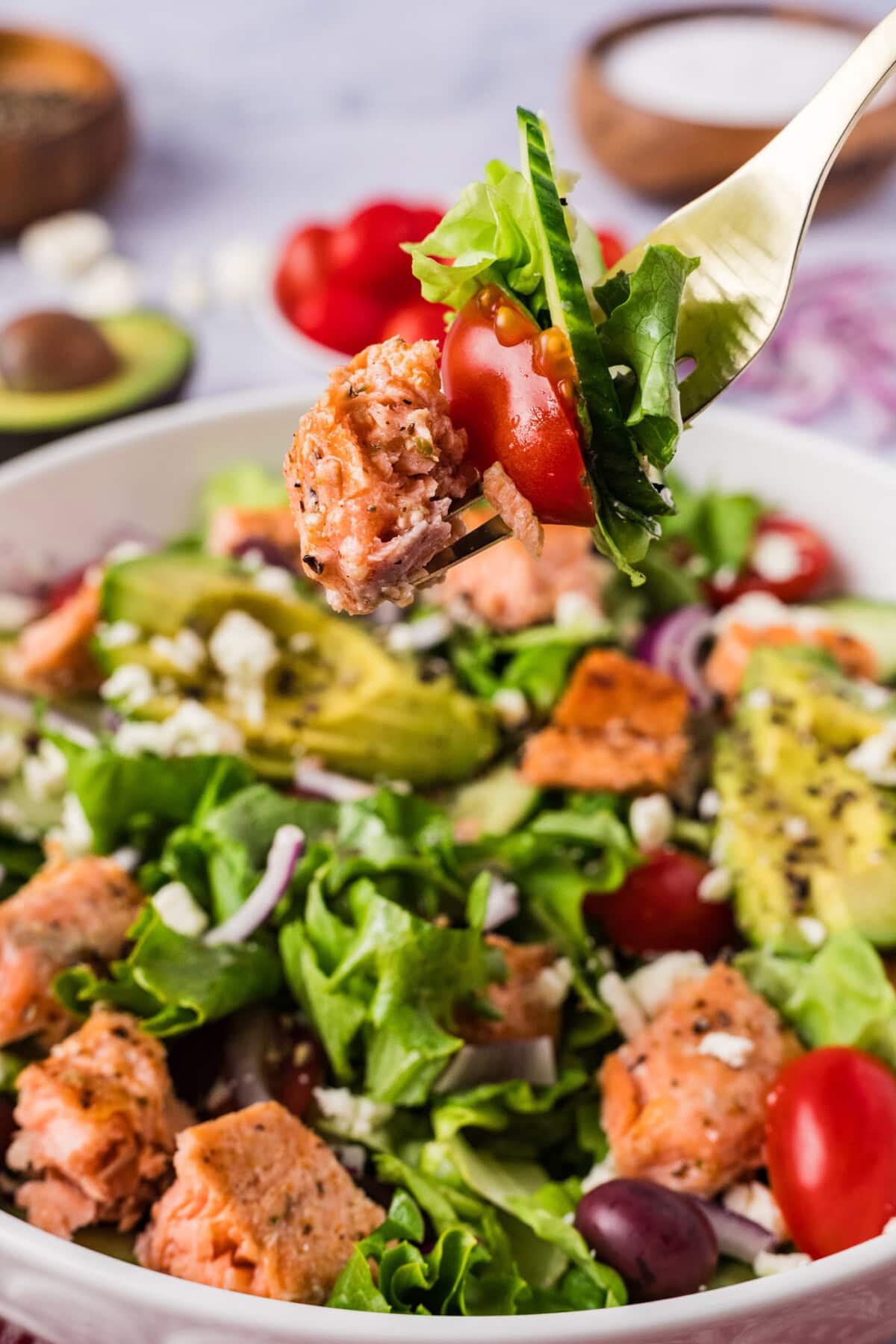 Forkful of Salmon Salad held above a bowl of Salmon Salad