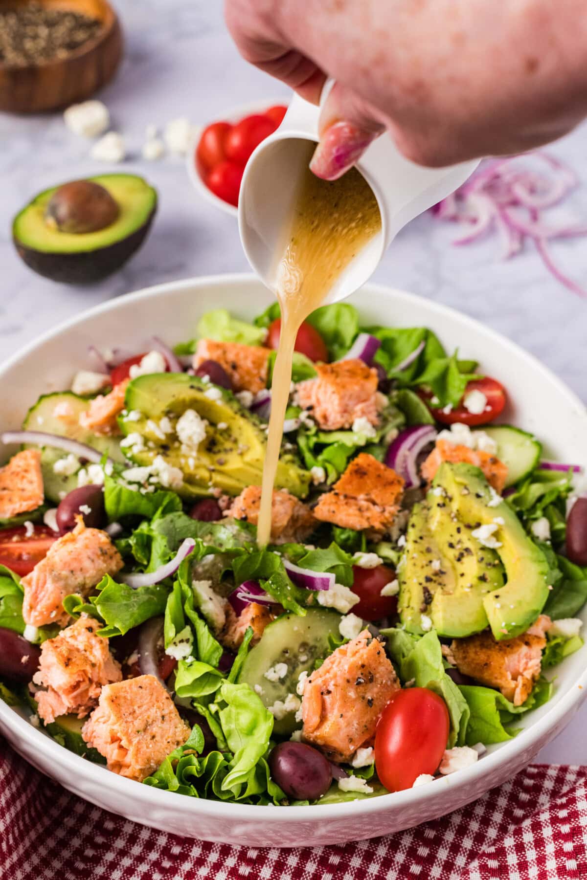 Dressing being poured over Salmon Salad