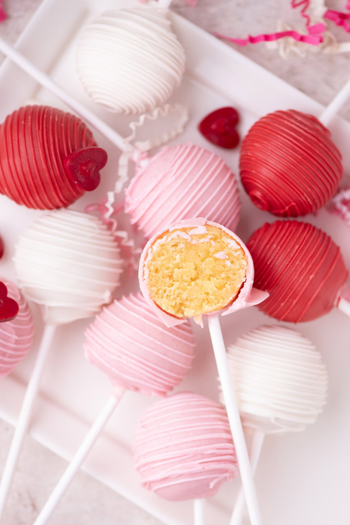 Valentine Cake Pops resting on a plate with one cute in half