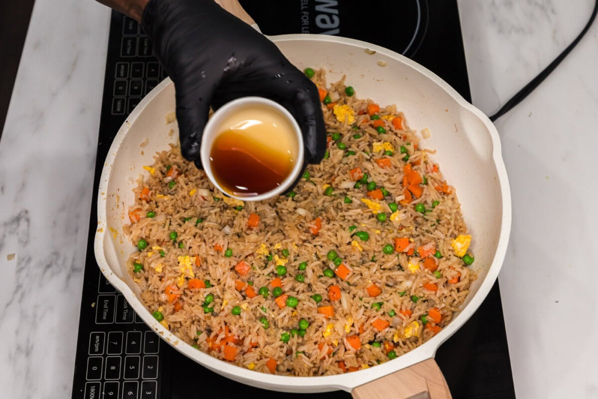 pouring sesame oil into v vegetable fried rice