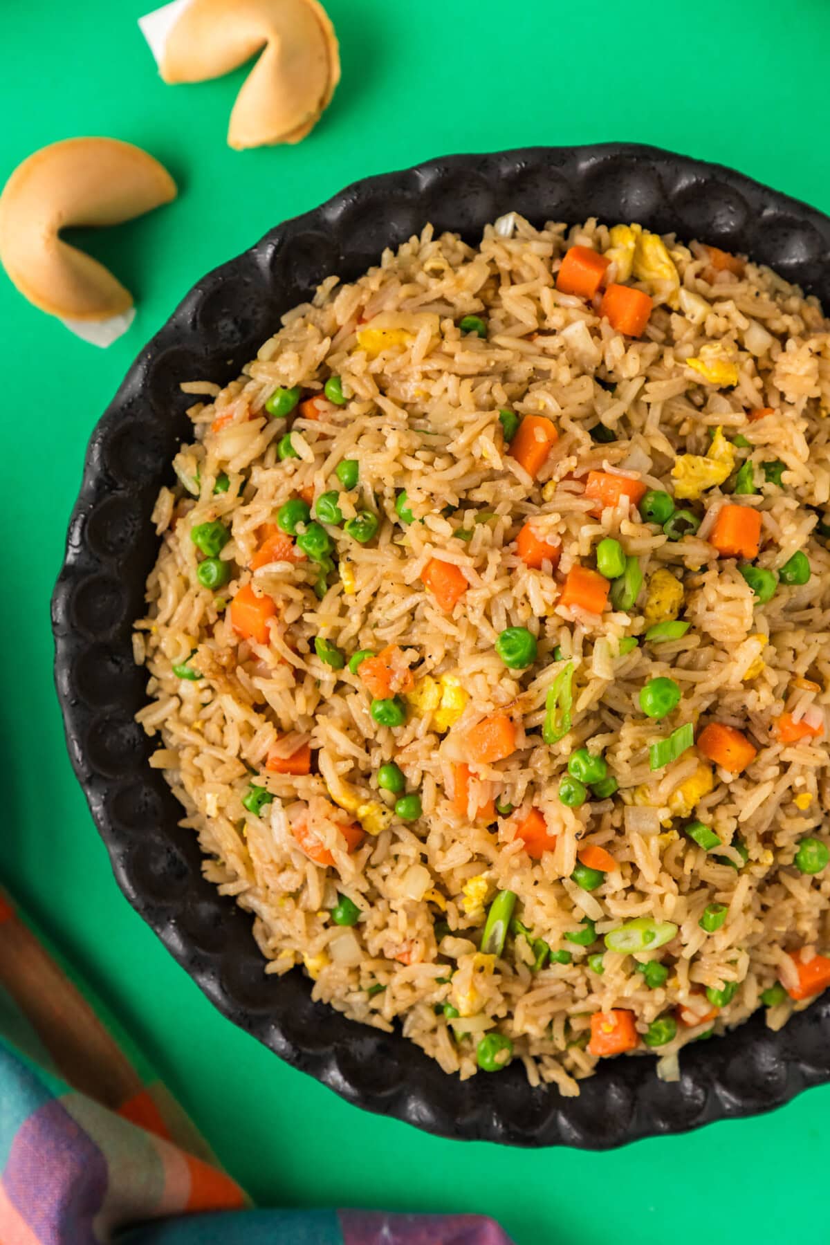 Half a bowl of Fried Rice with fortune cookies to the side