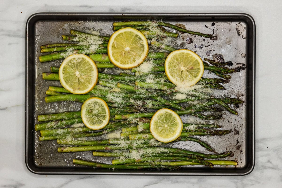 lemon asparagus on a baking pan wih parmesan cheese