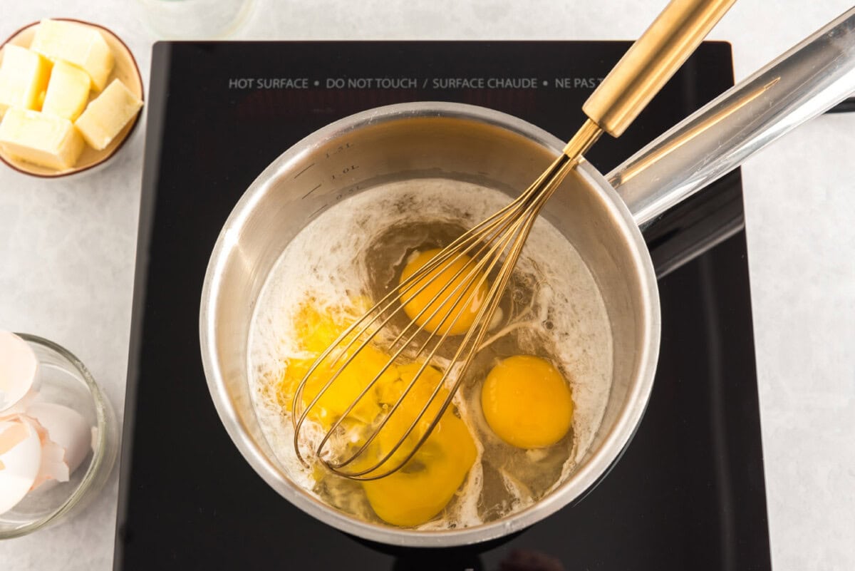 whisking eggs with buttermilk in a saucepan