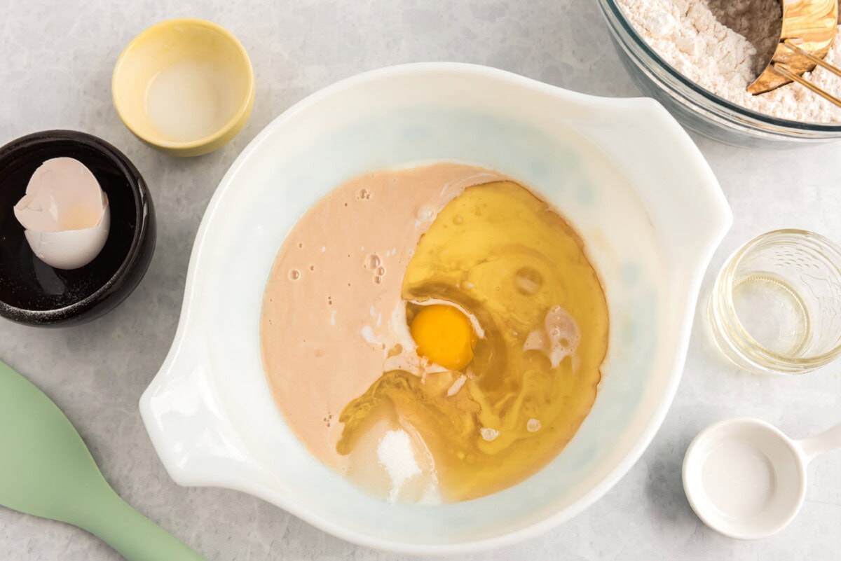 sugar, buttermilk, egg, and oil added to lemon sweet roll dough in a bowl